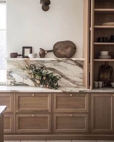 a kitchen with marble counter tops and wooden cabinets