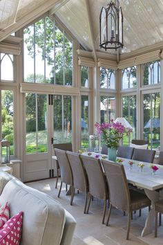 a dining room table and chairs in front of large windows