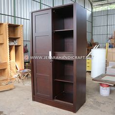 a tall wooden cabinet sitting inside of a warehouse