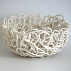 a white bowl that is sitting on a table with some kind of wire in it