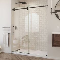 a bathroom with white walls and wood flooring next to a mirror on the wall