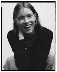 a black and white photo of a smiling woman