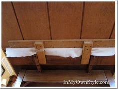 a wooden bench with two white towels hanging from it