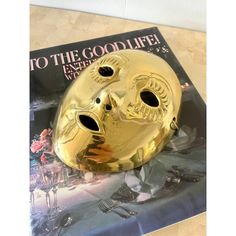 a gold mask sitting on top of a magazine