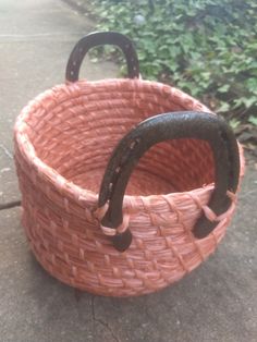 an empty pink basket sitting on the sidewalk