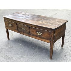 an old wooden table with three drawers on one side and two handles on the other