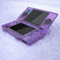 a purple plastic case holding a game system on it's back side, with the screen partially open