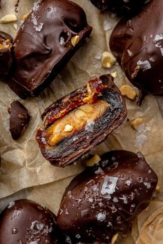 chocolate covered donuts with nuts and sea salt on top, sitting on parchment paper