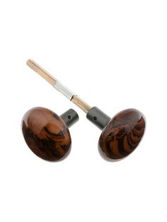 two wooden ear plugs with wood handles and metal tips, one is brown and the other is black