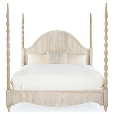 a white bed with four posts and pillows on it's headboard, in front of a white background