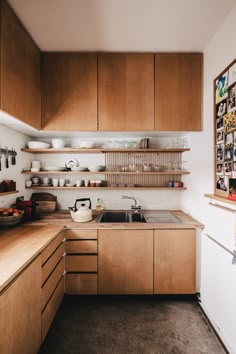 a kitchen filled with lots of wooden cabinets and counter top space next to a sink