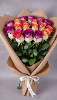 a bouquet of colorful roses wrapped in brown paper