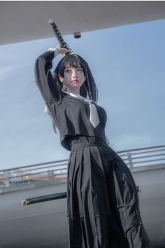 a woman in black and white dress holding a baseball bat over her head with both hands