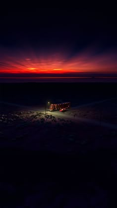 the sun is setting over an empty parking lot in the middle of the night, with cars parked on the side of the road