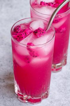 two glasses filled with pink liquid and ice