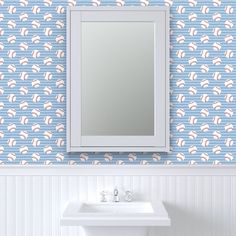 a white sink sitting under a bathroom mirror next to a wall mounted faucet