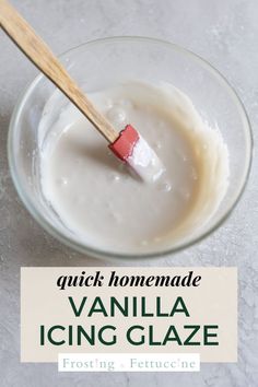 a glass bowl filled with vanilla icing and a wooden spoon sticking out of it