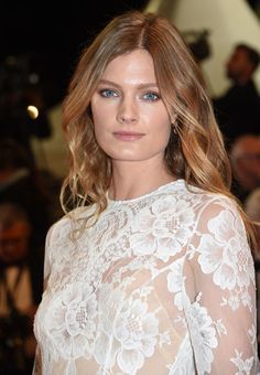 a woman with long hair and blue eyes is posing for the camera at an event