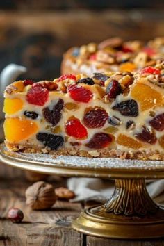 Gros plan sur une tranche de cake aux fruits confits colorés, posé sur un plateau doré avec une théière en arrière-plan. Dessert Aux Fruits, Simple Cake, Raisin, D Art, Fruit