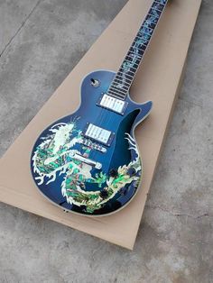 a blue electric guitar sitting on top of a cardboard box