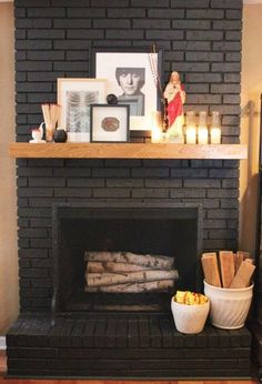 a fireplace with candles and pictures on it