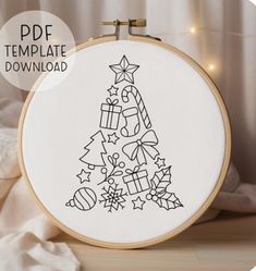 a cross - stitch christmas tree with presents on it is displayed in front of a white background