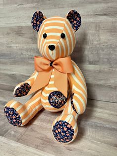 a teddy bear with an orange and white striped bow