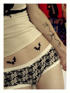 a woman's stomach with a cat tattoo on her lower body and the bottom part of her panties