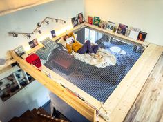 a woman laying on top of a bed in a room with wooden floors and walls