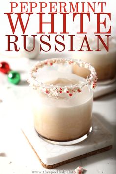 two glasses filled with white russian drink sitting on top of a table next to candy canes