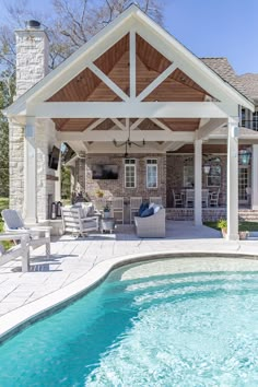 an outdoor living area next to a swimming pool and covered patio with seating around it