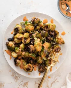 a white plate topped with brussel sprouts covered in caramel sauce