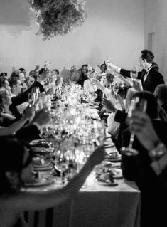 a group of people sitting at a long table with wine glasses in front of them