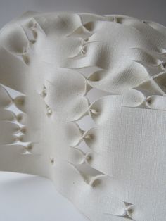 an upholstered piece of fabric with small holes in the middle and white background