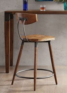 a wooden chair sitting in front of a table with a vase on top of it