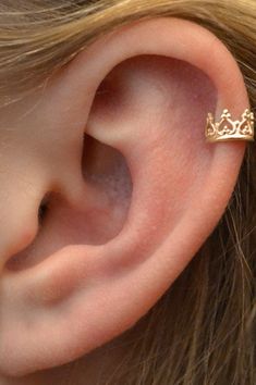 a woman's ear with a gold crown on it