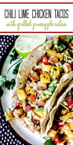 two chicken tacos with grilled pineapple salsa on a white plate and garnished with cilantro