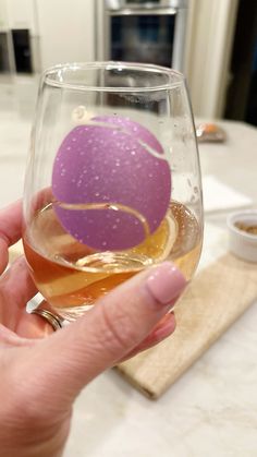 a person holding a wine glass with an object in it