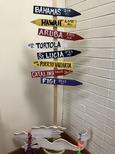 a bunch of signs that are on top of a wooden stand in front of a wall