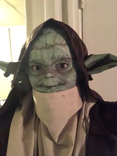 yoda star wars costume with mask and scarf on head, looking at the camera