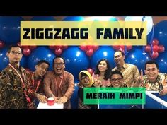 a group of people standing next to each other in front of balloons with the words ziggaggg family on it