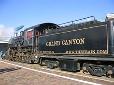 an old fashioned train is parked on the tracks