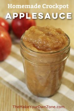 an apple pie in a glass jar next to some apples