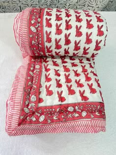 two red and white pillows sitting on top of each other