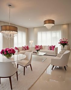 a living room filled with white furniture and pink flowers on top of a glass table