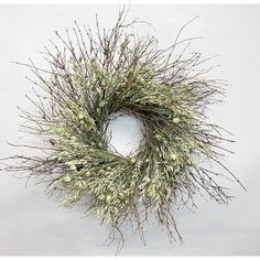 a dried wreath with white flowers and green stems on a white background, ready to be used as an ornament