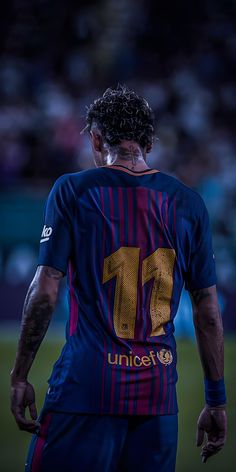 a soccer player with his back turned to the camera, wearing a number 11 shirt