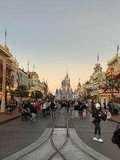 people are walking down the street in front of some buildings