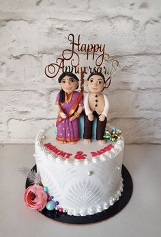 a happy anniversary cake with two figurines on top