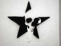 a black and white drawing of a star with a skull on it's side